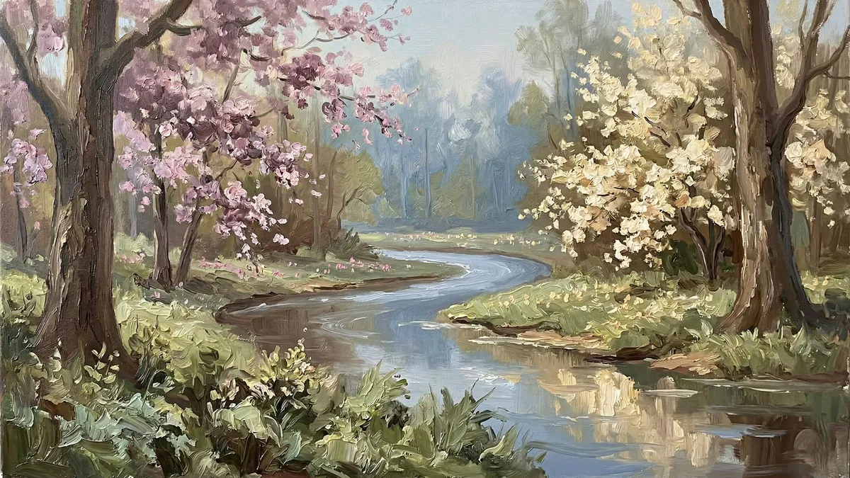 Winding river through a spring woodland with pink and cream blossoming trees, green banks and distant blue haze