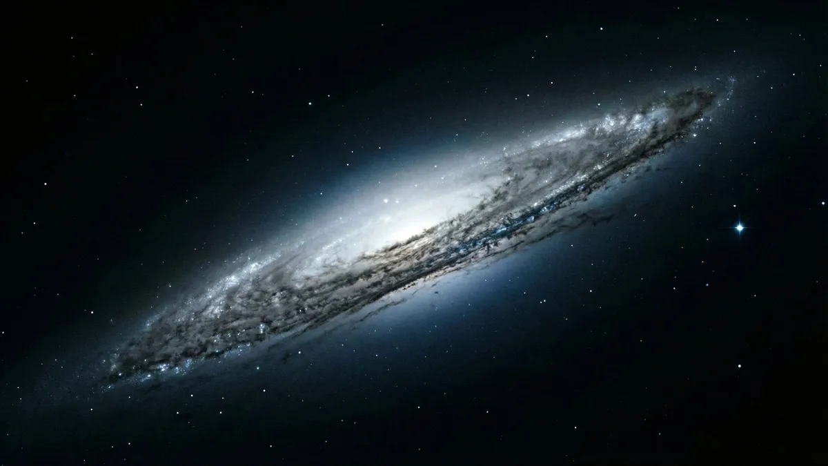 A tilted, edge-on spiral galaxy with a bright white core and dark dust lanes against a black, star-dotted sky